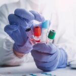 Stock photo of Laboratory worker holding blood vials